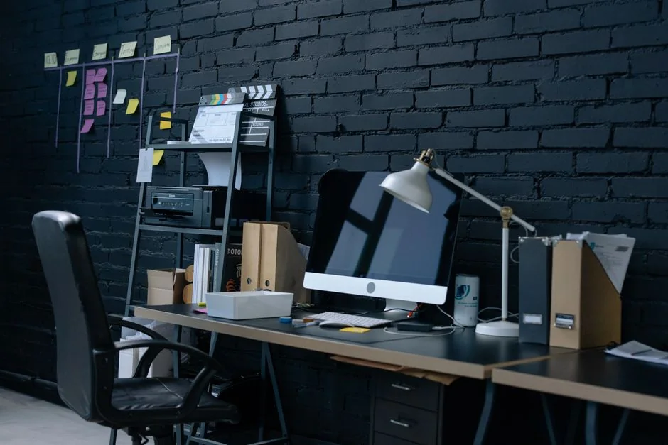 Close-up of an artist designing fashion sketches while seated at a desk indoors.